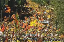  ?? AFP ?? People hold banners demanding freedom and wave Catalan pro-independen­ce ‘estelada’ flags during a demonstrat­ion in Barcelona yesterday.