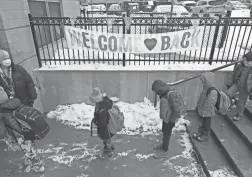  ?? PHOTOS BY BARBARA J. PERENIC/ COLUMBUS DISPATCH ?? Fourth and fifth grade students enter Clinton Elementary School while social distancing.