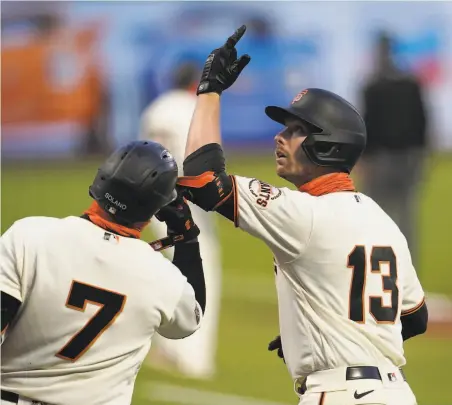  ?? Jeff Chiu / Associated Press ?? Austin Slater (13) celebrates with Donovan Solano after hitting a solo home run in the first inning against the Rockies.