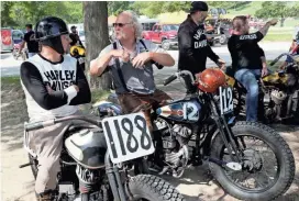  ?? MICHAEL SEARS / MILWAUKEE JOURNAL SENTINEL ?? Chris McGregor (left) of Oklahoma City, Oklahoma, on his 1942 Harley-Davidson WLA, and Kem Runnebacke of New Bern, North Carolina, on his 1937 Harley-Davidson WLD, discuss the race course and bikes as they wait for their turn on the oval.