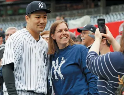  ?? AP PHOTO/ KATHY WILLENS ?? New York Yankees starting pitcher Masahiro Tanaka, left, poses for a photo with a fan before a baseball game against the Cleveland Indians in New York, Sunday, May 6, 2018.
