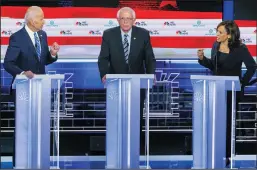  ?? AL DIAZ/MIAMI HERALD ?? Sen. Kamala Harris (D-Calif.), right, speaks to former Vice President Joe Biden, left, as Sen. Bernie Sanders (I-Vt.) looks on during the second night of the first Democratic presidenti­al debate on Thursday at the Arsht Center for the Performing Arts in Miami.