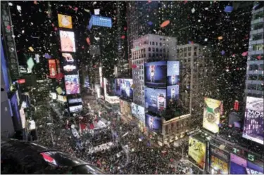  ?? THE ASSOCIATED PRESS ?? Confetti drops over the crowd as the clock strikes midnight during the New Year’s celebratio­n in Times Square as seen from the Marriott Marquis in New York, Monday, Jan. 1, 2018.