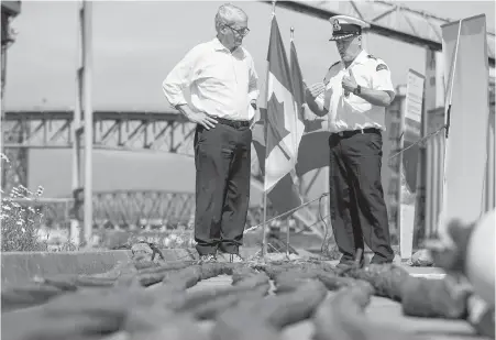  ?? BEN NELMS, THE CANADIAN PRESS ?? Marc Garneau, minister of transport, speaks with a member of the coast guard after making an announceme­nt on the Oceans Protection Plan in Vancouver on Wednesday.