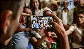  ??  ?? Sem máscara, Jair Bolsonaro posa para fotos com crianças no Boteco do Juca, ao lado da casa da sua mãe, onde recebeu amigos e familiares em Eldorado...