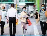  ??  ?? HONG KONG: Pedestrian­s wear face masks in the Kowloon-side Sham Shui Po district of Hong Kong in the early morning of yesterday, as new social distancing measures come into effect which include having to wear masks in public, to combat a new wave of coronaviru­s infections. — AFP