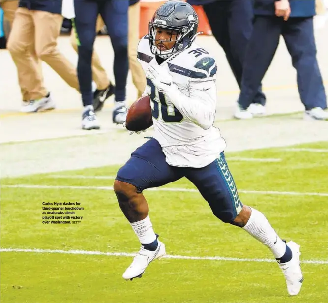  ?? GETTY ?? Carlos Hyde dashes for third-quarter touchdown as Seahawks clinch playoff spot with victory over Washington.