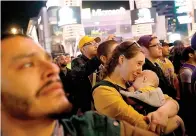  ?? Genaro Molina/Los Angeles Times/TNS ?? ■ A mother is overcome with emotion while watching a pregame tribute to Kobe Bryant with hundreds of fans standing Friday outside LA Live in downtown Los Angeles. Bryant’s fans came out to pay tribute to the Lakers star who died in a helicopter crash on Jan. 26.