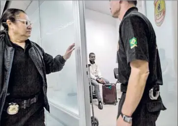  ?? Photograph­s by Flavio Forner For The Times ?? SECURITY AGENTS at Brazil’s Guarulhos Internatio­nal Airport, just outside Sao Paulo, detain Emmanuel, a Nigerian suspected of swallowing cocaine capsules and trying to board a f light to Ethiopia.