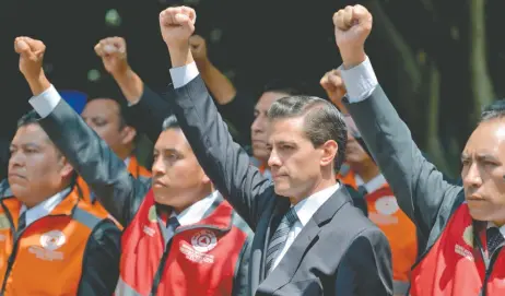  ??  ?? El presidente Enrique Peña Nieto, acompañado de brigadista­s de Protección Civil, levantó el puño derecho para recordar a las personas que perdieron la vida en el sismo del 19 de septiembre de 2017.