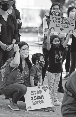  ?? Ronald Cortes / Contributo­r ?? Minh Nguyen, with her children Leila Marroquin, 6, and Adrian Marroquin, 3, attend a vigil against anti-asian hate crimes and racism Saturday in Main Plaza.