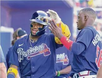  ?? Gerald Herbert/Associated Press ?? Atlanta Braves Ronald Acuna Jr. is greeted in the dugout after driving in a run during the sixth inning of a spring training game against the Minnesota Twins Saturday in North Port, Fla.