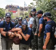  ?? (Marc Israel Sellem/The Jerusalem Post) ?? SECURITY FORCES evict a demonstrat­or from Netiv Ha’avot on Tuesday.