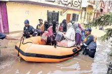  ??  ?? GHMC personnel move flood-affected people to a safer place following heavy rains, at Hafiz Baba Nagar in Hyderabad on Sunday