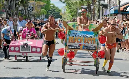  ?? FLORIDA KEYS NEWS BUREAU/REUTERS ?? Participan­ts in the Conch Republic Red Ribbon Bed Race roll down Duval St in Key West, Florida as part of annual celebratio­ns marking the Florida Keys’ 1982 ‘‘secession’’ from the United States, prompted by the installati­on of a Border Patrol...