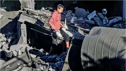  ?? ?? A Palestinia­n boy recovers pigeons from the rubble of a building destroyed following Israeli bombardmen­t on Rafah, in the southern Gaza Strip. (AFP)