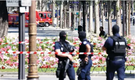  ??  ?? French police at the scene of an incident in which a car rammed a gendarmeri­e van on the Champs-Elysees Avenue in Paris on Monday. (Reuters)