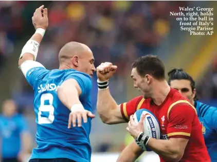  ??  ?? Wales’ George North, right, holds on to the ball in front of Italy’s Sergio Parisse Photo: AP