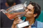  ?? CHRISTOPHE ENA / AP 2009 ?? Roger Federer kisses the trophy after defeating Robin Soderling in the men’s singles finals of the French Open on June 7, 2009. Federer has won 20 Grand Slam titles, but only one in Paris.