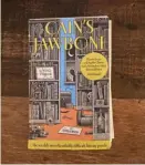  ?? Hannah Natanson/Washington Post ?? The reporter's copy of "Cain's Jawbone," which has been cut apart and bound back together in what she fervently hopes is the correct order of pagination.