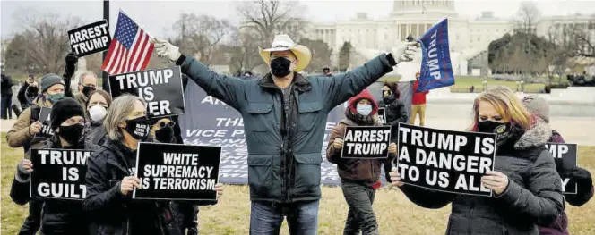  ?? REUTERS / CARLOS BARRIA ?? Un partidario del presidente Donald Trump rodeado por un grupo de detractore­s del republican­o en las inmediacio­nes del Capitolio en Washington, el viernes.