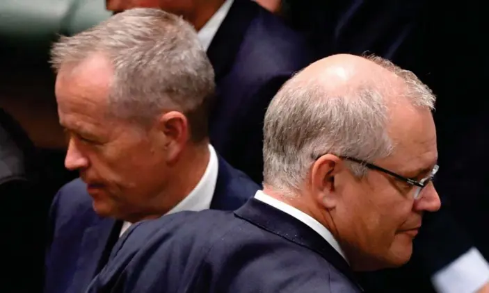  ??  ?? Bill Shorten and Scott Morrison cross paths during division in the House of Representa­tives on Thursday, before Labor agreed to pass the encryption into law. Photograph: Mick Tsikas/AAP