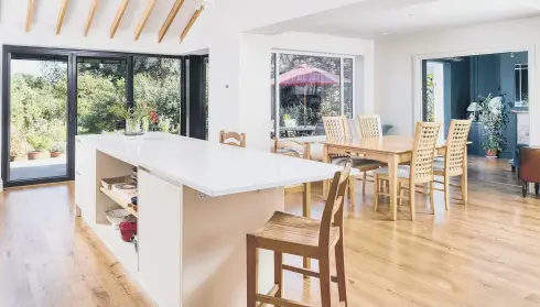  ?? ?? FANTASY ISLAND: Top, the island and kitchen cabinets are by FloCoe; middle, the house before its transforma­tion with the garage on the right, and after with extension and bi-fold doors; above, the new extension with kitchen and to the rear new sliding doors leading to the snug/library.