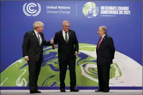  ?? (AP/Christophe­r Furlong) ?? British Prime Minister Boris Johnson (left) and U.N. Secretary-General Antonio Guterres (right) greet Australian Prime Minister Scott Morrison on Monday at the U.N. climate summit in Glasgow, Scotland.