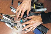  ?? Jessica Christian / San Francisco Chronicle ?? Principal Maureen Byrne of Dublin High School in Dublin, Calif., sifts through vaporizer pens, e-cigarettes and Juul-branded smoking devices confiscate­d from students.
