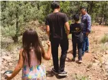  ?? OLIVIA HARLOW THE NEW MEXICAN ?? Selim Sandoval leads three of his children, 12-year-old Mayaan, 15-year-old Renzo and 6-year-old Gaba, earlier this month down a path he and his family built.