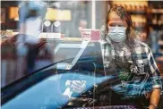  ?? Ting Shen / New York Times file photo ?? A Whole Foods Market employee, wearing a face mask amid the pandemic, runs a cash register in Washington in April.