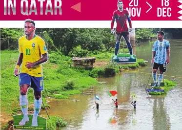  ?? — AFP ?? Diehard supporters: Fans wave flags next to giant cutouts of brazil’s Neymar, Portuguese Cristiano ronaldo and argentine Lionel messi, in river Cherupuzha at Kozhikode in India’s Kerala.