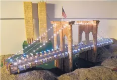  ??  ?? There are no traffic jams here on the model of the Brooklyn Bridge Bill Falkenthal built out of wine bottle corks. The bridge was built on a boulder in his basement. The Twin Towers can be seen behind it.