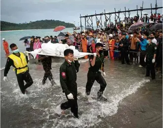  ?? Ye Aung Thu/AFP ?? Militares de Mianmar retiram corpo encontrado no mar, em área onde avião desaparece­u