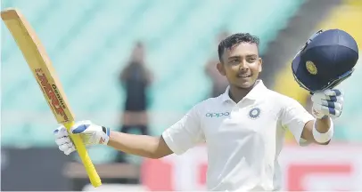  ?? Picture: AFP ?? WONDERBOY. India’s Prithvi Shaw raises his bat after scoring his century on debut on the first day of the first Test against the West Indies in Rajkot yesterday.