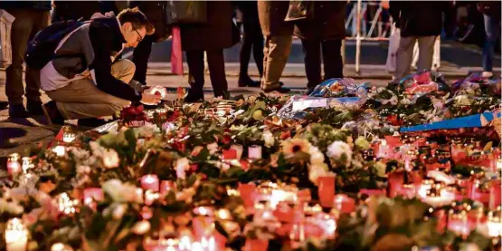  ?? Clemens Bilan/AFP ?? Berlinense­s depositam flores e velas na igreja Kaiser-Wilhelm, que fica ao lado do mercado de Natal atingido por um caminhão na noite de segunda (19)