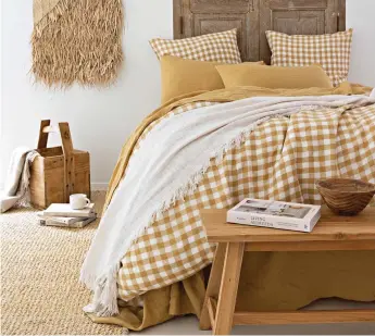  ?? ?? Bold neutrals: Yellow bed linen and natural textiles create a relaxing room