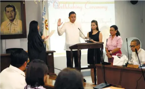  ?? (SUN.STAR FOTO/ALLAN CUIZON) ?? NEW PB MEMBER. Danao City MTCC Judge Maria Josefa Ramos (left, standing) officiated the oathtaking of Danao City Councilor Miguel Antonio Magpale as an appointed member of the Provincial Board before the Danao City Council. With him is his wife,...