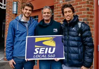  ?? PAT GREENHOUSE/GLOBE STAFF ?? Dartmouth players Cade Haskins (left) and Romeo Myrthil (right) were happy to stand with Chris Peck, president of the campus workers’ union.