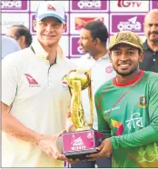  ??  ?? Steven Smith (L) and Mushfiqur Rahim (R) hold the tournament trophy during the presentati­on ceremony following second Test between Bangladesh and Australia in Chittagong