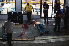  ??  ?? MANILA: Photo shows a body of an alleged drug user on the ground after unidentifi­ed gunmen shot him dead in Manila. —AFP