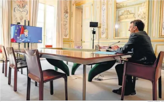  ?? THOMAS SAMSON / EFE ?? El presidente francés, Emmanuel Macron, atiende a la canciller alemana, Angela Merkel, por videoconfe­rencia desde el Palacio del Elíseo, en París.