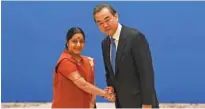  ?? - Madoka Ikegami/Pool via Reuters ?? WARM GREETINGS: Indian Foreign Minister Sushma Swaraj, left, shakes hands with Chinese State Councillor and Foreign Minister Wang Yi before a meeting of foreign ministers and officials of the Shanghai Cooperatio­n Organisati­on at the Diaoyutai State...