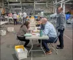  ?? Alexandra Wimley/Post-Gazette ?? Allegheny County elections workers review provisiona­l ballots with authorized representa­tives from Dave McCormick and Mehmet Oz’s campaigns on May 23 on the North Side.