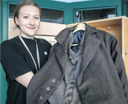  ?? DAVE SIDAWAY ?? Kate Bauer shows a replica of a men’s sack suit, a garment manufactur­ed in Montreal in the first part of the 20th century at Harris Vineberg’s Progress Brand. The former factory is the subject of a walking tour titled Inside the Shmatte Factory, offered by the Museum of Jewish Montreal.