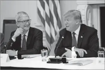  ?? [DOUG MILLS/THE NEW YORK TIMES] ?? Tim Cook, left, the chief executive of Apple, sits with President Donald Trump at an American Workforce Policy Advisory Board meeting in March at the White House. Friday, Trump assailed Cook for continuing to rely on foreign manufactur­ers.