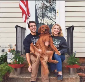  ?? Olivia Hinerfeld / Associated Press ?? In this photo provided by Olivia Hinerfeld, Olivia Hinerfeld poses with her boyfriend, Ryan Shymansky, and their golden retriever Lincoln on Dec. 6 in Washington. Jealous of the attention that Hinerfeld is paying to her video conference call, Lincoln will fetch “the most disgusting” tennis ball he can find from his toy crate to drop into the lap of the Georgetown University Law School student.