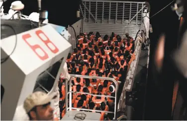  ?? Kenny Karpov / SOS Mediterran­ee ?? Aid group SOS Mediterran­ee released a photo of rescued migrants preparing to board its ship Aquarius.