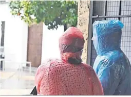  ?? ?? Dos personas se resguardan del aguacero en un soportal.