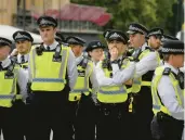  ?? VADIM GHIRDA/AP ?? Police gather Sunday in London, where more than 10,000 officers will be on duty Monday, officials say.